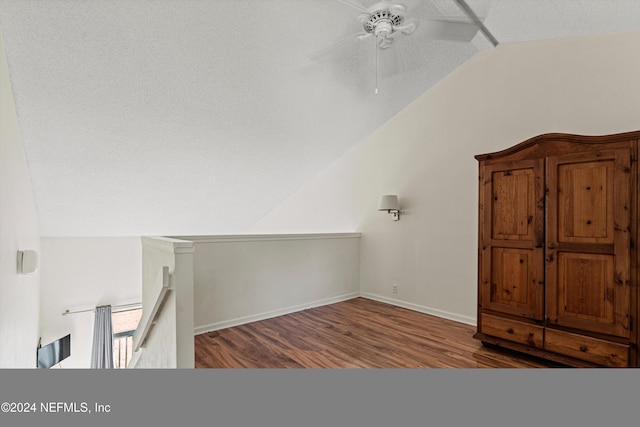 interior space with hardwood / wood-style flooring, ceiling fan, lofted ceiling, and a textured ceiling