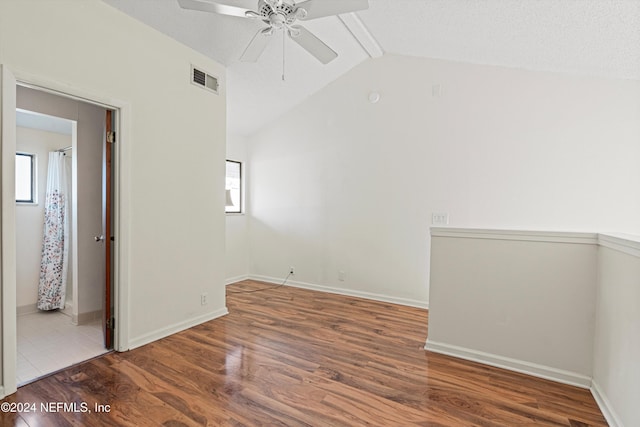 spare room featuring hardwood / wood-style floors, a textured ceiling, vaulted ceiling, and ceiling fan