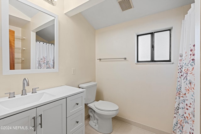 bathroom with tile patterned flooring, vanity, toilet, and vaulted ceiling