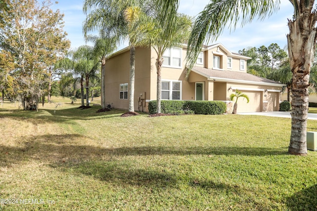 view of property with a garage and a front lawn