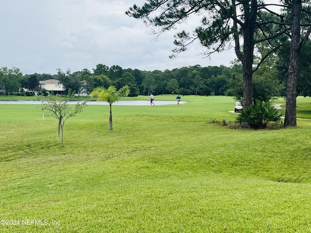 view of home's community featuring a water view and a lawn