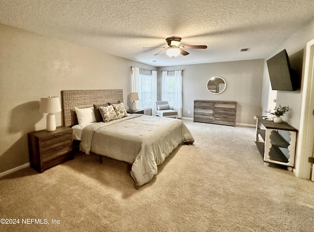 carpeted bedroom featuring a textured ceiling and ceiling fan