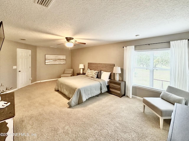 bedroom with carpet flooring, ceiling fan, and a textured ceiling