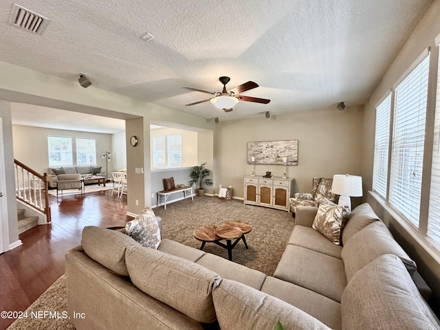 living room featuring a textured ceiling, ceiling fan, and dark hardwood / wood-style floors