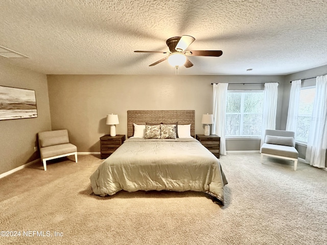 carpeted bedroom featuring a textured ceiling and ceiling fan