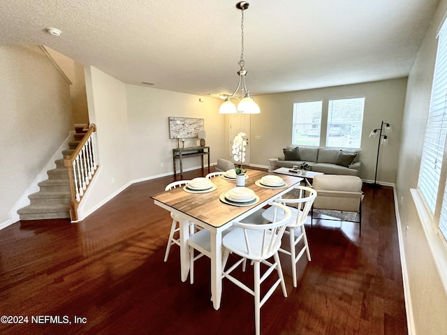 dining space with a textured ceiling and dark wood-type flooring