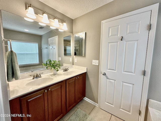 bathroom with tile patterned flooring, vanity, and a textured ceiling