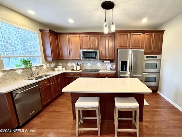 kitchen with dark hardwood / wood-style flooring, stainless steel appliances, a kitchen island, and backsplash