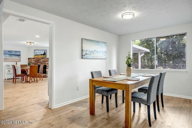 dining room featuring a textured ceiling and light wood-type flooring