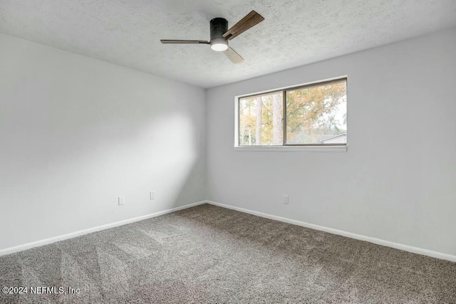 carpeted spare room featuring ceiling fan and a textured ceiling