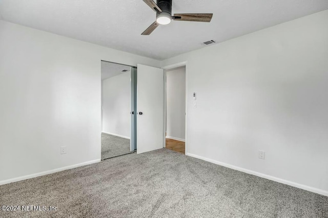 unfurnished bedroom with carpet flooring, ceiling fan, and a closet