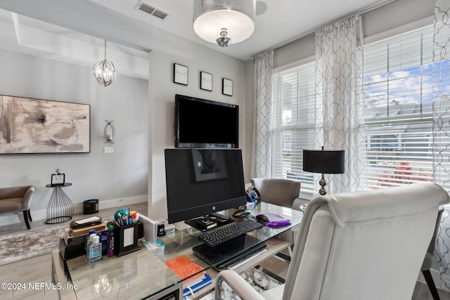 home office with wood-type flooring and a chandelier