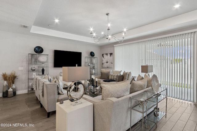 living room with an inviting chandelier and a tray ceiling