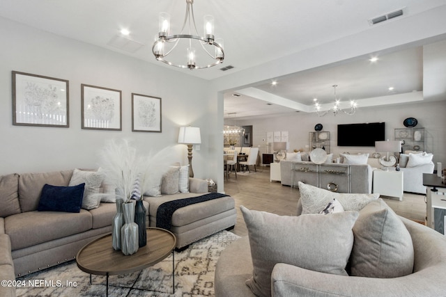 living room with an inviting chandelier and light hardwood / wood-style flooring