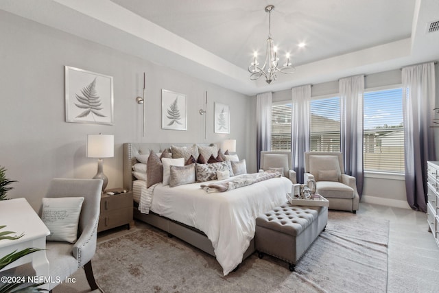 carpeted bedroom with a notable chandelier and a raised ceiling