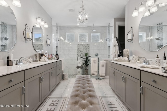 bathroom featuring tiled shower, tile patterned floors, vanity, and a notable chandelier