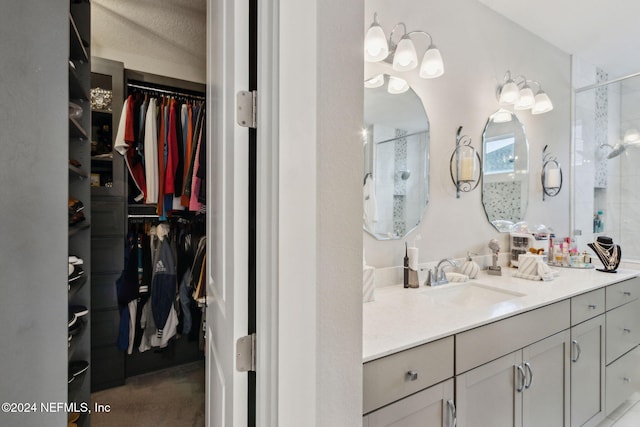 bathroom featuring vanity, an enclosed shower, and a textured ceiling