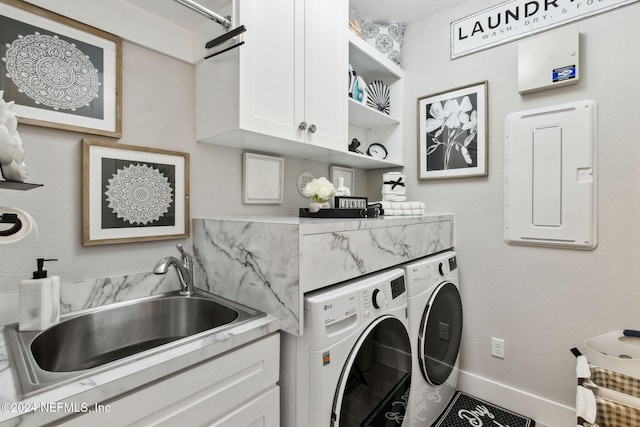 laundry room with cabinets, washing machine and dryer, sink, and electric panel