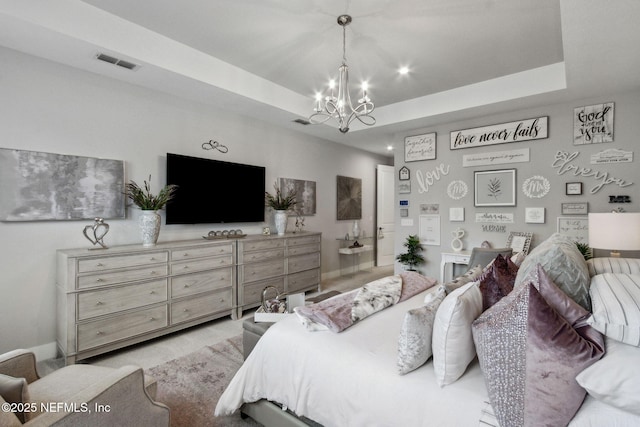 bedroom featuring a raised ceiling and a chandelier