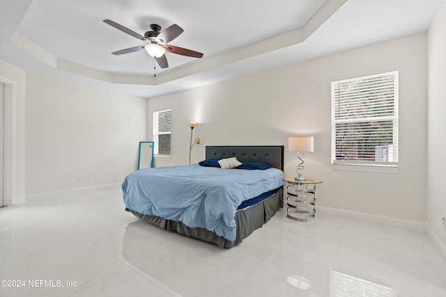 bedroom with a raised ceiling and ceiling fan