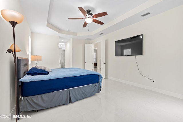 bedroom with ceiling fan and a tray ceiling