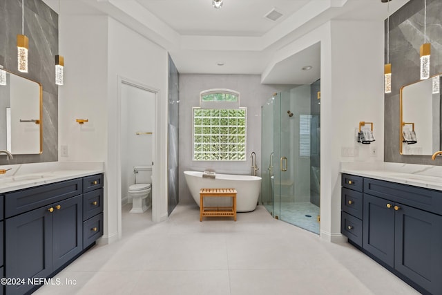 full bathroom featuring tile patterned floors, vanity, a raised ceiling, shower with separate bathtub, and toilet