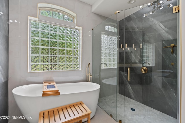 bathroom featuring shower with separate bathtub