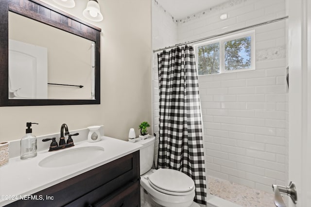 bathroom featuring vanity, toilet, and walk in shower