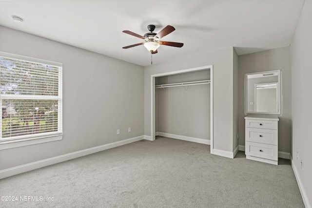 unfurnished bedroom with ceiling fan, light colored carpet, and a closet