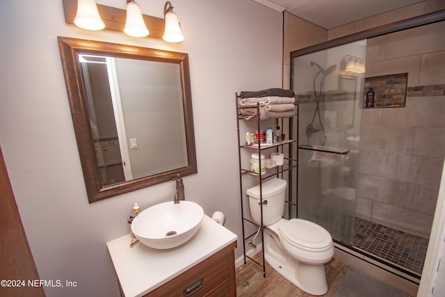 bathroom featuring hardwood / wood-style floors, vanity, toilet, and a shower with door