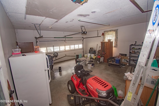 garage featuring white fridge and a garage door opener