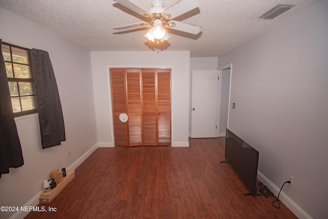 unfurnished bedroom featuring hardwood / wood-style flooring, ceiling fan, a textured ceiling, and a closet