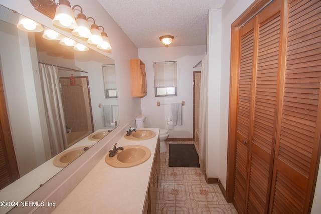 bathroom with tile patterned floors, vanity, a textured ceiling, toilet, and curtained shower