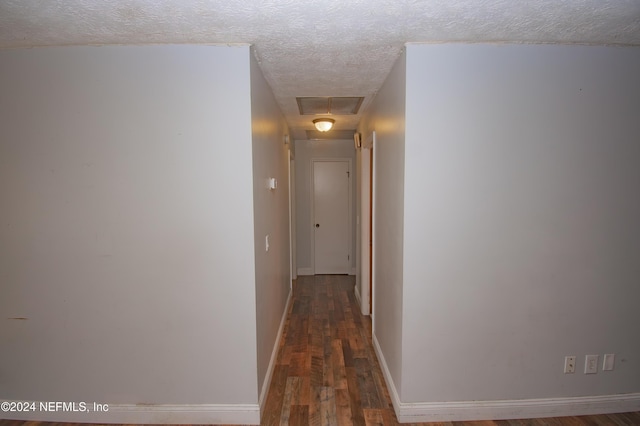 corridor featuring dark hardwood / wood-style floors and a textured ceiling