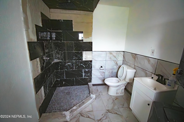 bathroom featuring toilet, vanity, tile walls, and walk in shower