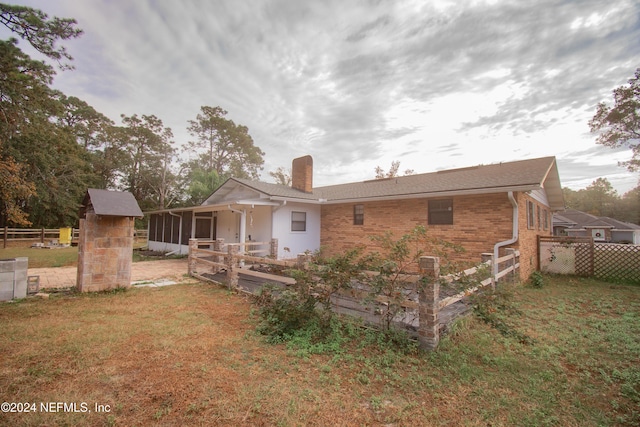 rear view of property featuring a lawn