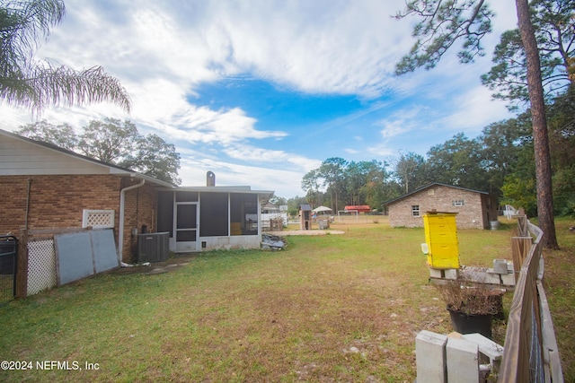 view of yard featuring a sunroom and central AC unit