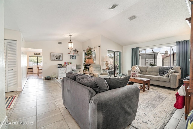 tiled living room featuring a textured ceiling and vaulted ceiling