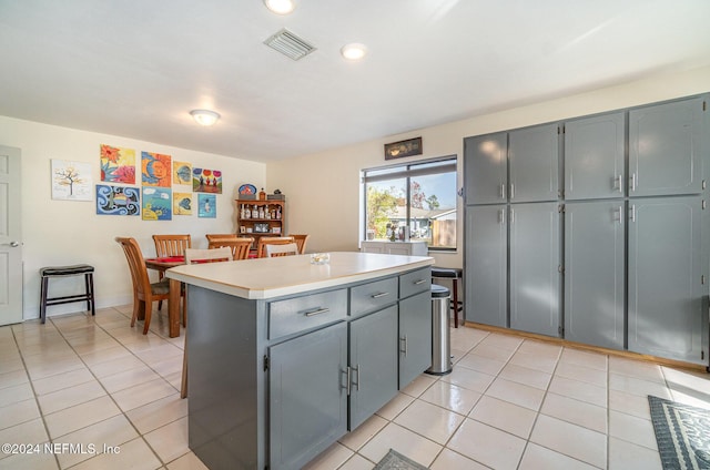 kitchen featuring gray cabinetry, a kitchen island, and light tile patterned floors