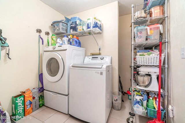 clothes washing area featuring light tile patterned floors and washing machine and dryer