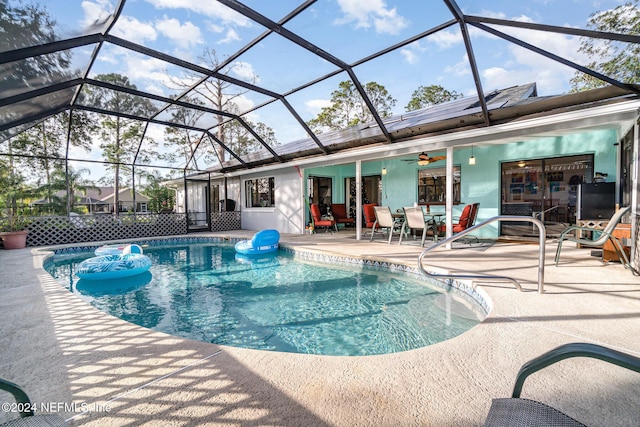 view of pool featuring ceiling fan, a patio area, and a lanai