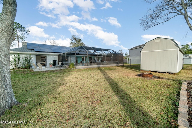 view of yard with glass enclosure, a patio area, and a storage shed