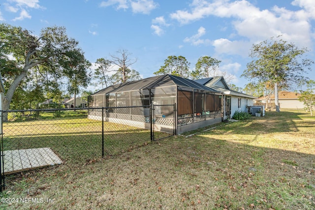 view of side of property featuring a yard and glass enclosure