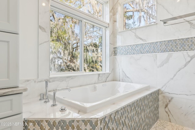 bathroom featuring a relaxing tiled tub