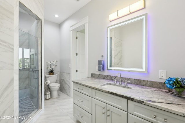 bathroom with vanity, tile walls, walk in shower, and toilet