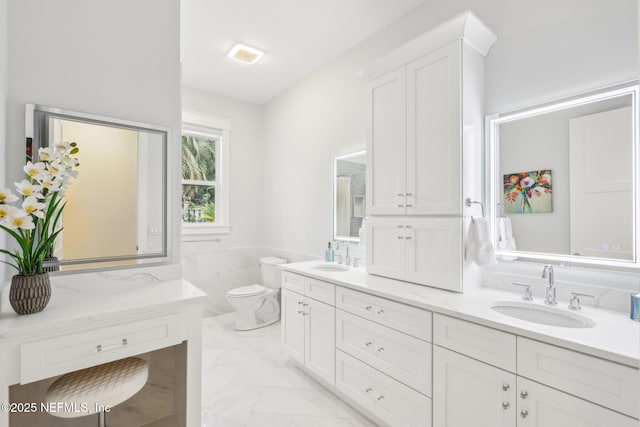 bathroom with vanity, toilet, and tile walls