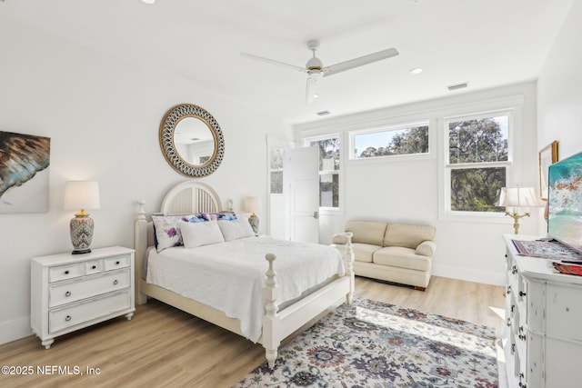 bedroom featuring ceiling fan, multiple windows, and light wood-type flooring