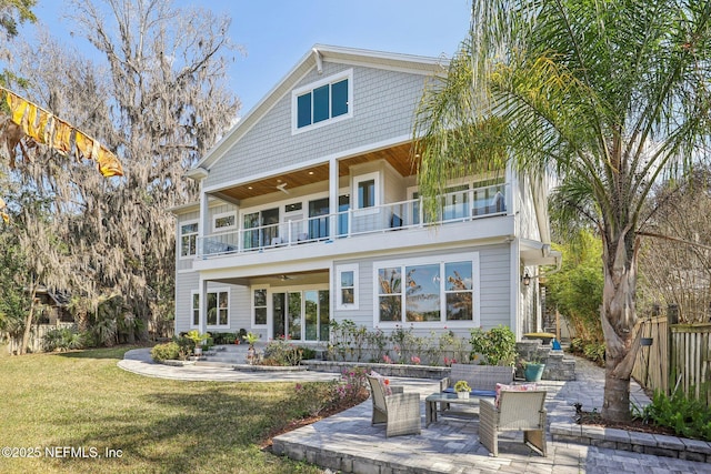 back of house featuring ceiling fan, a yard, a patio, an outdoor hangout area, and a balcony