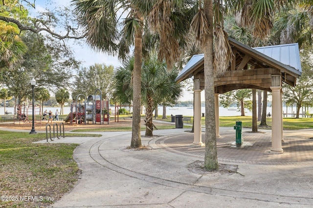 surrounding community featuring a playground and a water view