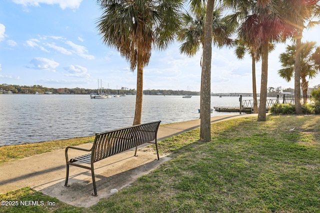 view of property's community with a water view and a yard